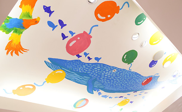 地下1階天井はクジラや色彩豊かな鳥、地球、風船や花々が